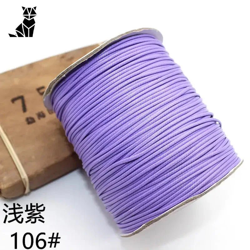 Gros plan d’une bobine de fil violet avec une boîte pour la fabrication d’un bracelet personnalisé avec photo d’animal