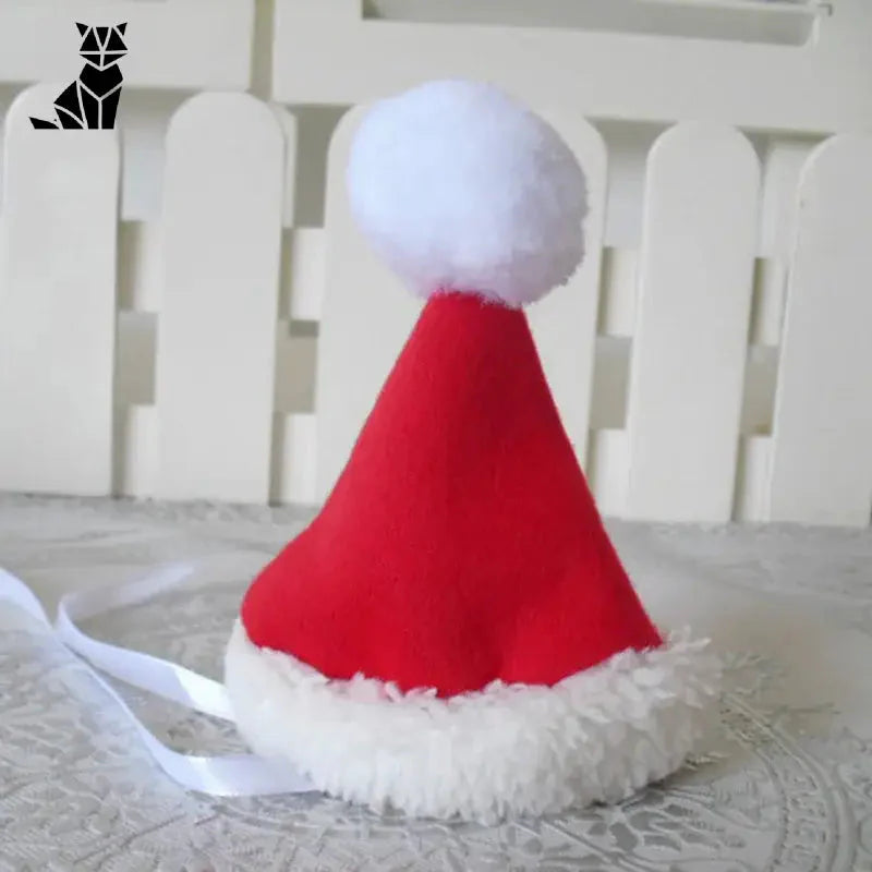 Père Noël bonnet rouge et blanc sur la table - Costume de Noël pour chat festif
