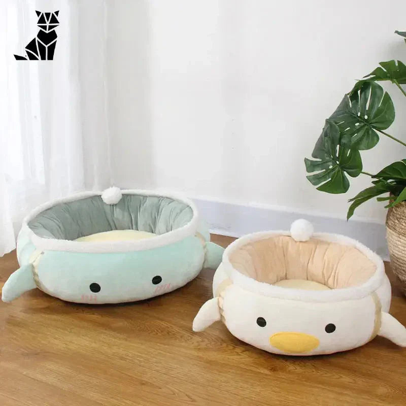 Deux petites peluches assises sur le sol avec Espace Douillet pour Chats - Hamac Rond et Chaud